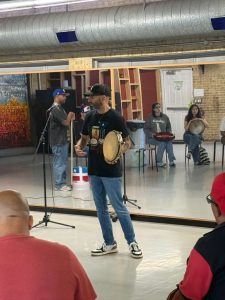 Participants learning to play panderetas during the plena percussion workshop in Austin.
